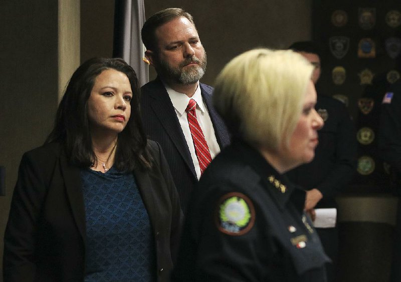 Mona Hernandez (left), a U.S. Postal Inspection Service team leader, and Cody Hiland, U.S. Attorney for the Eastern District of Arkansas, listen Monday afternoon to interim Little Rock Police Chief Alice Fulk speak about an initiative with the U.S. Postal Service, Little Rock Police Department and others to federally prosecute mail thieves. 