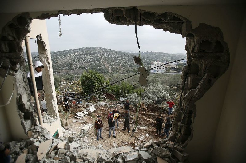 Palestinians examine a house after it was partially demolished by the Israeli army in the village of Shweikeh, near the West Bank city of Tulkarem, on Monday.