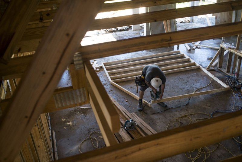 A worker saws a section of lumber inside a home under construction at the M/I Homes Inc. Bougainvillea Place housing development in Ellenton, Fla., on July 6, 2017. MUST CREDIT: Bloomberg photo by Ty Wright.