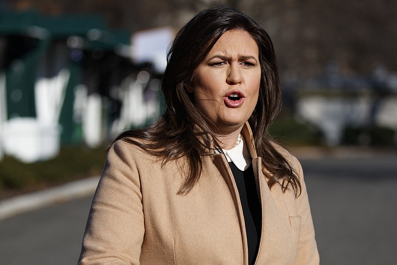 White House press secretary Sarah Huckabee Sanders talks with reporters outside the White House, Tuesday, Dec. 18, 2018, in Washington. (AP Photo/Evan Vucci)