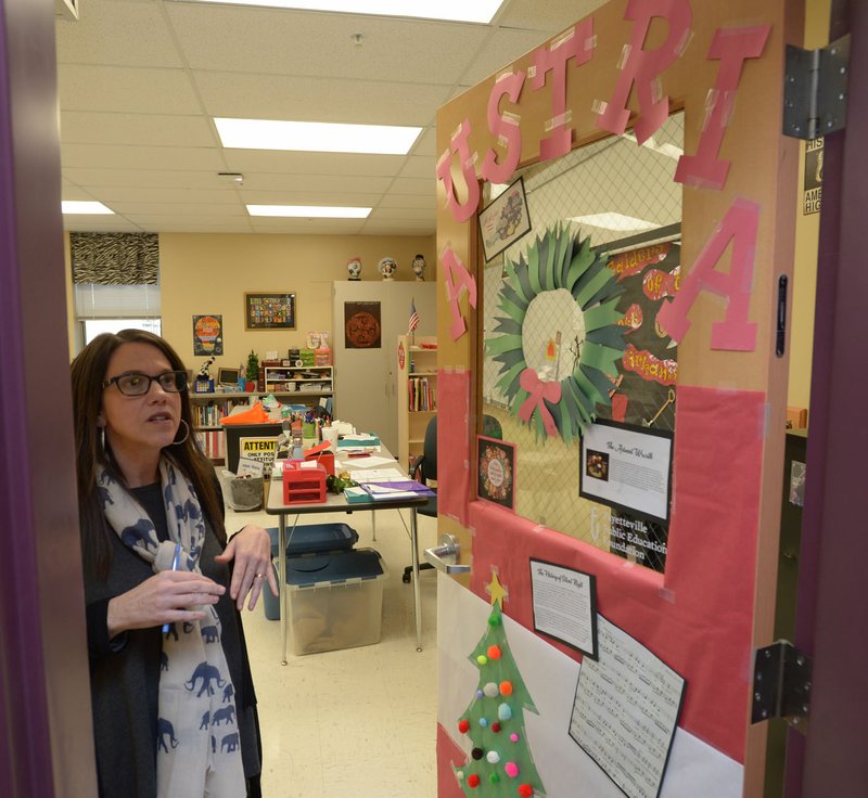 NWA Democrat-Gazette/ANDY SHUPE Carol Huneycutt, gifted and talented teacher at McNair Middle School, shows Tuesday the door to her classroom students designed and decorated explaining Austria and its holidays as a part of the Fayetteville school's effort to learn countries and the holidays celebrated around the world between November and March. Homerooms around the school created 43 decorated doors from 43 countries.