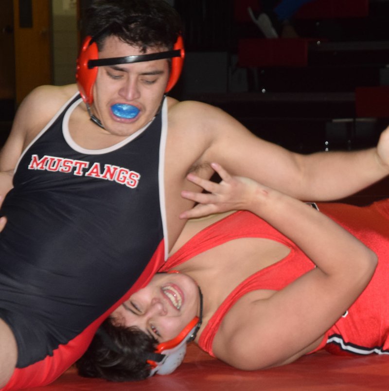 RICK PECK/SPECIAL TO MCDONALD COUNTY PRESS McDonald County's Jesus Ocampo pins Grove's Marco Gonzales' head to the mat before pinning his shoulders later on in the match during the Mustangs' 62-18 loss on Dec. 13 at Grove High School.