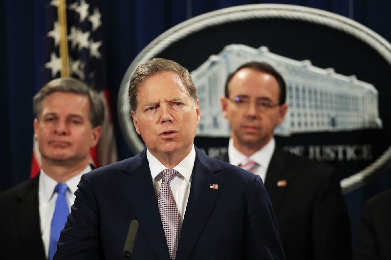 U.S. Attorney Geoffrey Berman of New York, with FBI Director Christopher Wray (left) and U.S. Deputy  Attorney General Rod Rosenstein, speaks Thursday about the indictment of two Chinese citizens suspected of cyber-espionage. 