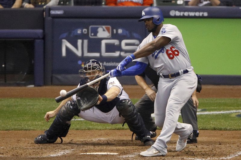 FILE - In this Oct. 20, 2018, file photo, Los Angeles Dodgers' Yasiel Puig (66) hits a three -run home run during the sixth inning of Game 7 of the National League Championship Series baseball game against the Milwaukee Brewers in Milwaukee. The Dodgers shook up their National League-championship roster Friday, Dec. 21, 2018, trading Puig, Matt Kemp and left-hander Alex Wood and cash to the Cincinnati Reds for right-hander Homer Bailey. (AP Photo/Charlie Riedel, File)