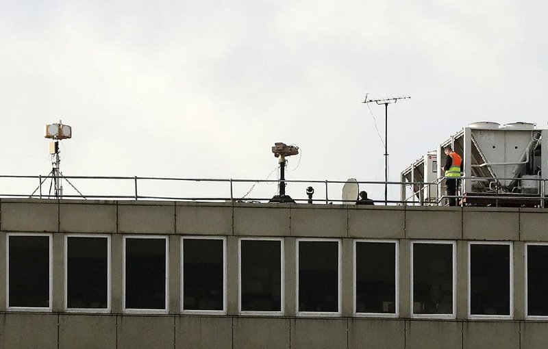 Counter drone equipment is deployed on a rooftop at Gatwick airport Saturday as the airport and airlines work to clear the backlog of flights delayed by a drone incident last week, in Crawley, England. 