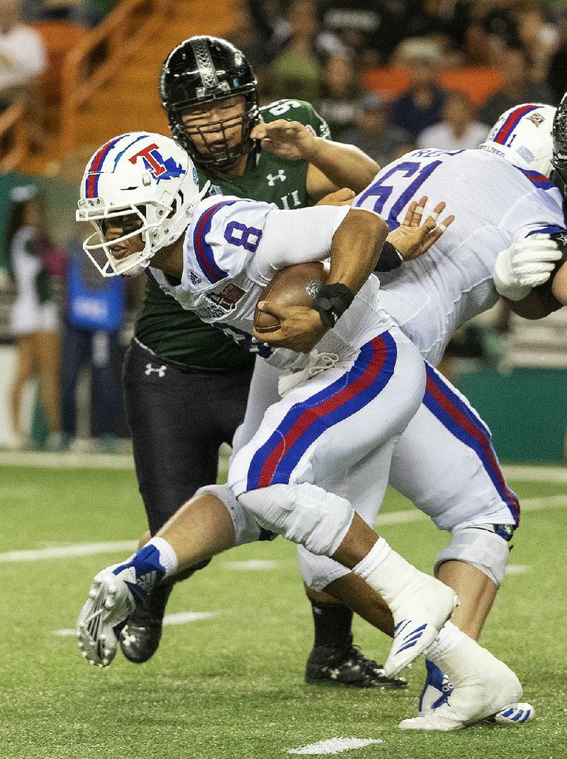 Louisiana Tech quarterback J’Mar Smith (8) scrambles out of the pocket in the second half of the Hawaii Bowl on Saturday in Honolulu. Smith threw a touchdown pass and ran for another score to lead Louisiana Tech to a 31-14 victory.