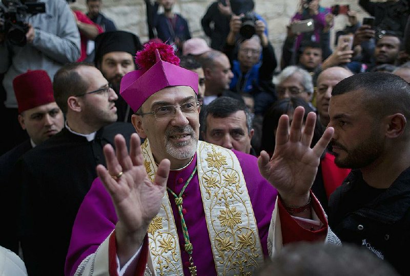 Archbishop Pierbattista Pizzaballa, the top Roman Catholic cleric in the Holy Land, arrives in in the West Bank city of Bethlehem on Monday after crossing through an Israeli military checkpoint from Jerusalem, ahead of midnight Mass at the Church of the Nativity. 