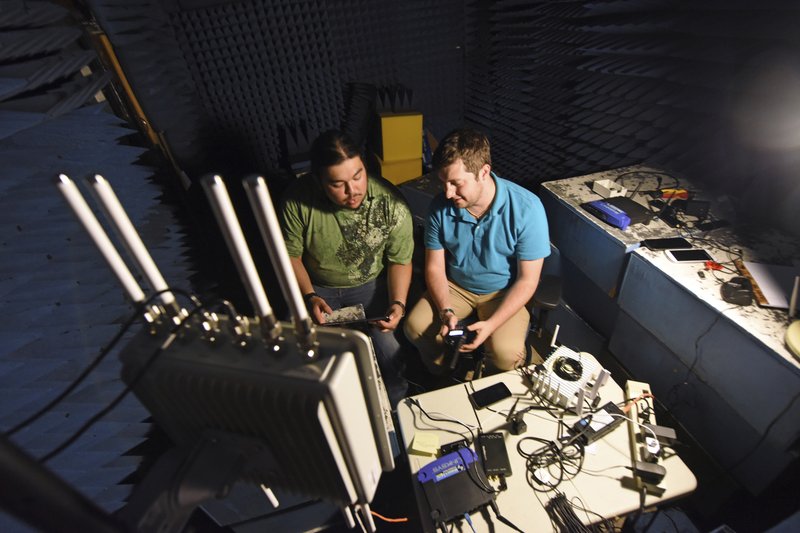In this September 2018 photo provided by the Idaho National Laboratory, INL interns Armando Juarez Jr., left, and Jordan Mussman work in the Faraday room in a cybersecurity electronics lab in Idaho Falls, Idaho. The Idaho National Laboratory next year will move into a massive cybersecurity building and another that will house one of the nation&#x2019;s most powerful supercomputers. (Chris Morgan/Idaho National Laboratory via AP)