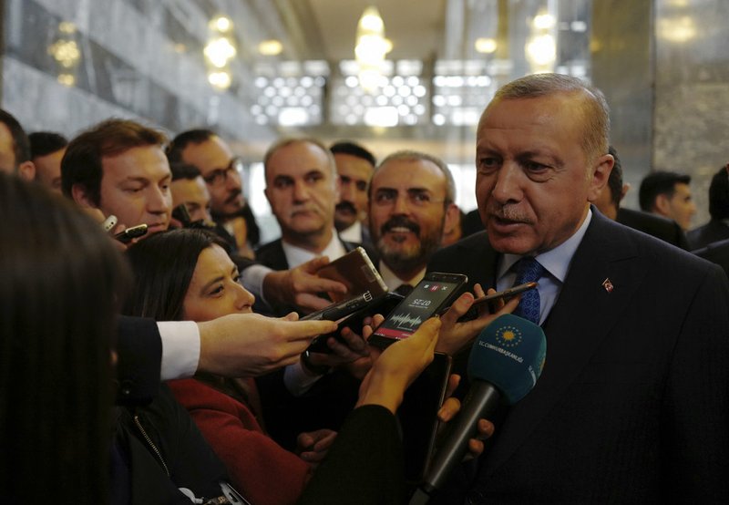 Turkey's President Recep Tayyip Erdogan speaks to reporters at the parliament in Ankara, Tuesday, Dec. 25, 2018. Erdogan said Turkey was taking into account Trump's announcement on Syria rather than French President Emmanuel Macron's decision. Turkish Foreign Minister Mevlut Cavusoglu also said Tuesday Turkey is working with the United States to coordinate the withdrawal of American forces but remains "determined" to clear U.S.-allied Kurdish fighters from northeastern Syria.