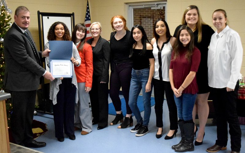 Westside Eagle Observer/MIKE ECKELS Steve Watkins presents the Decatur Lady Bulldog volleyball team with Decatur School District's "Bulldog Pride Award" during the Dec. 17 school board meeting in the conference room at Decatur Middle School. Included in the ceremony were Watkins (left) Desi Meek, Kaliey Sutherland, Tajhe Turner, Bronwyn Berry, Stephanie Sandoval, Natalie Rodriguez, Ithzel Martinez (front), Callie McBride and McKinzee Swaim.