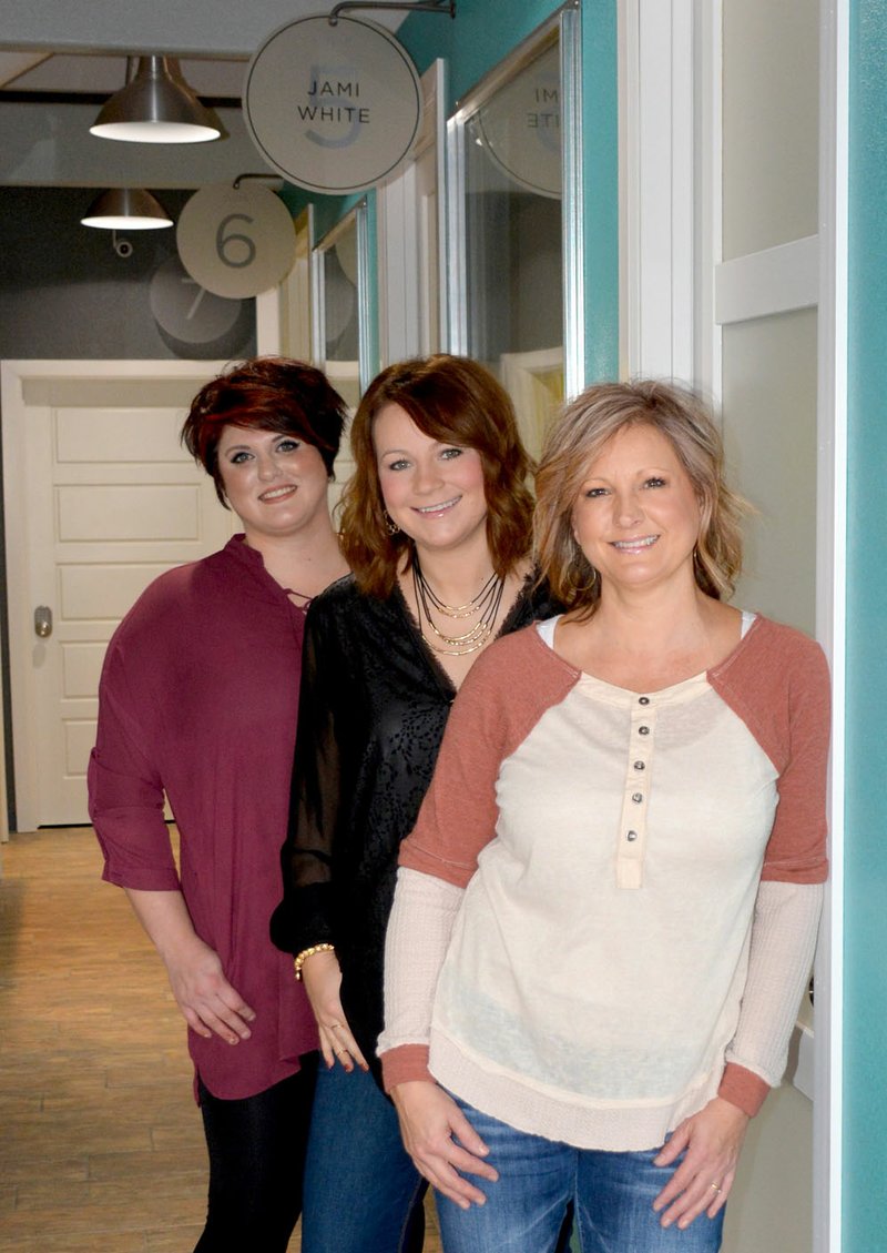 Janelle Jessen/Herald-Leader Stylists Jami White, left, and Hailey Osbourn, and owner Christy Osbourn, stood in the hallway of the Urban Edge Salon, which features individual signs for the private rooms in the salon suite. Under the new business model, professionals rent a room and operate their own business under the roof of the salon.