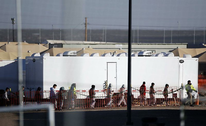 Migrant teens walk through the Tornillo detention camp in Tornillo, Texas, on Dec. 13. In the wake of the deaths an 8-year-old Guatemalan boy and a 7-year-old Guatemalan girl while in U.S. custody, officials have completed new medical screenings of children being detained on the border with Mexico. 