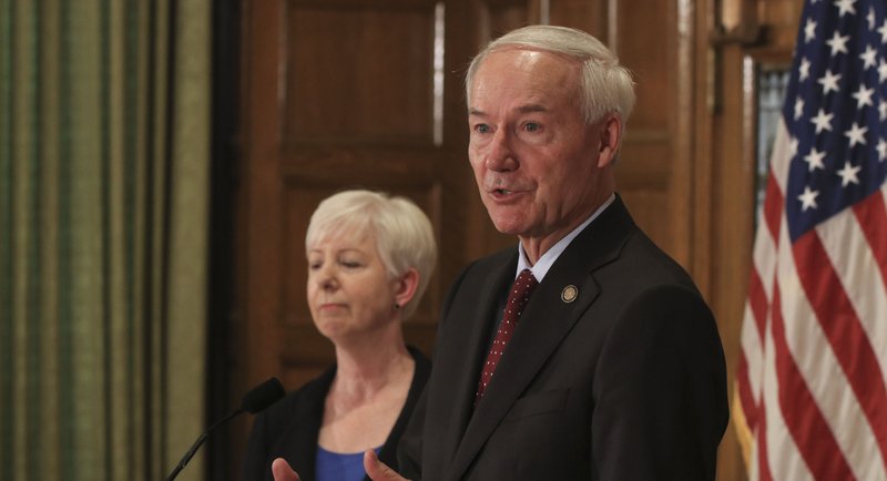  Gov. Asa Hutchinson (right) is shown speaking, along with DHS Director Cindy Gillespie, about changes in the juvenile justice system in this file photo.