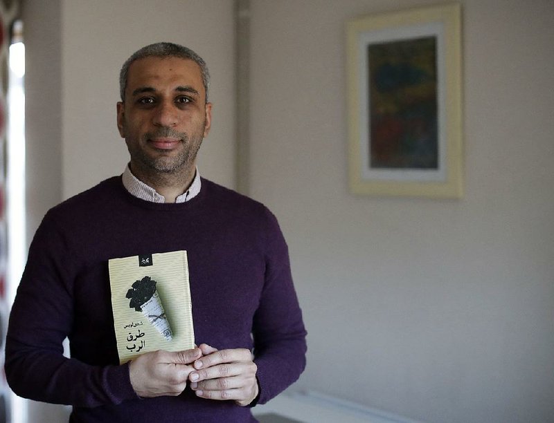 Journalist Shady Lewis Botros poses with a copy of his book, Ways of the Lord, in London. The new Arabic-language novel, the author’s first, explores the lives of Egyptian Christians, dealing with discrimination but also a church aligned with a state seeking to control them. 