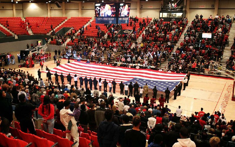 The American flag is draped across the court Thursday, Dec. 27, 2018, in an opening ceremony for the King Cotton Holiday Classic at the Pine Bluff Convention Center. It had been 19 years since the event last took place, and a crowd of nearly 2,000 watched the opening game as Miami Gulliver Prep defeated Columbus (Miss.) 52-50.