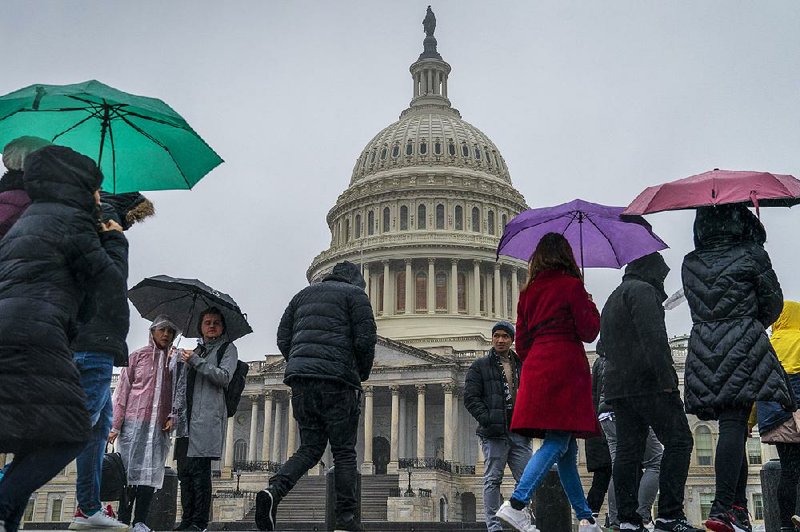 Rain greets tourists Friday morning at the U.S. Capitol. Congressional leaders have left Washington, but aides said they could return if an agreement to end the government shutdown is reached. 