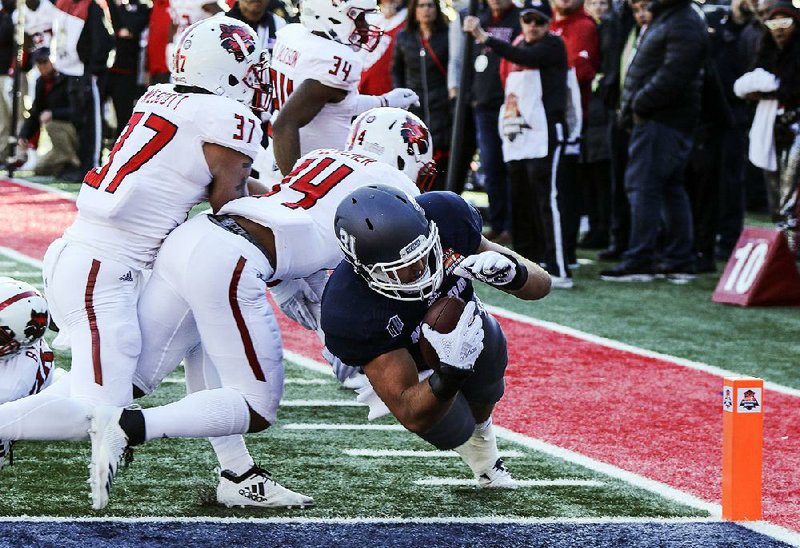 Nevada tight end Reagan Roberson dives into the end zone past Arkansas State’s Logan Wescott (37) and Antonio Fletcher (14) for the winning touchdown in overtime to give the Wolf Pack a 16-13 victory over Arkansas State on Saturday in the Arizona Bowl at Arizona Stadium in Tucson.