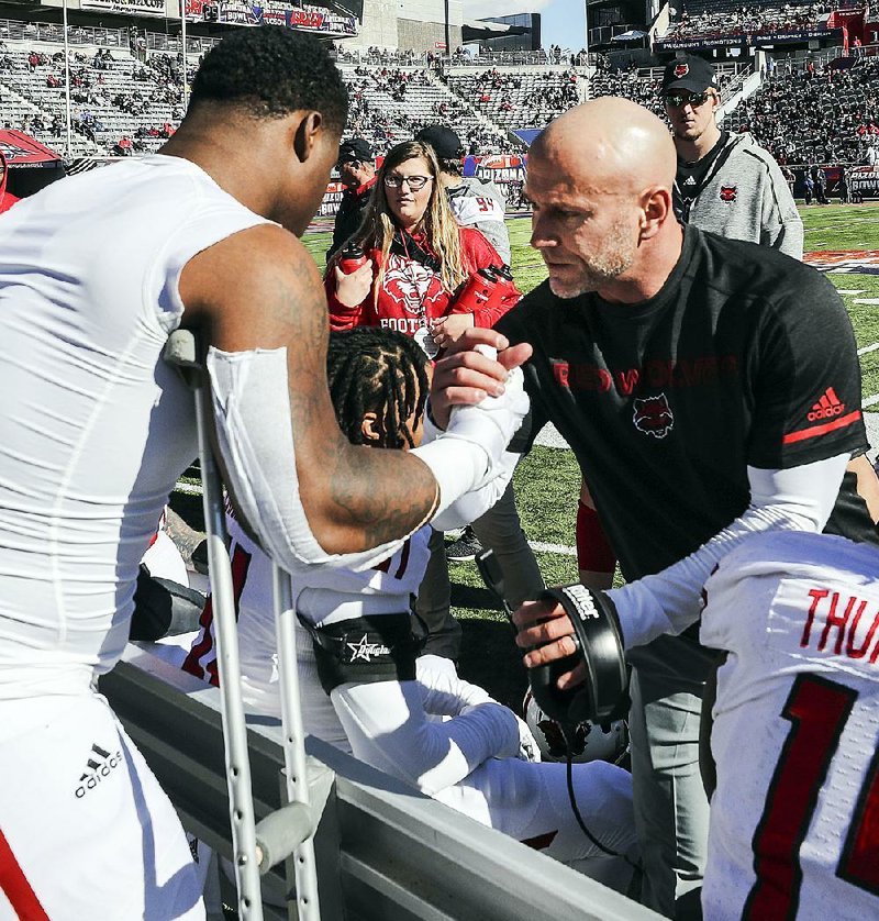 Arkansas State defensive end Ronheen Bingham gets some encouragement from defensive line coach Brian Early (right) after suffering a medial collateral ligament injury to his left knee during the first quarter of the Red Wolves’ loss to Nevada on Saturday. Bingham expects to undergo surgery Monday.