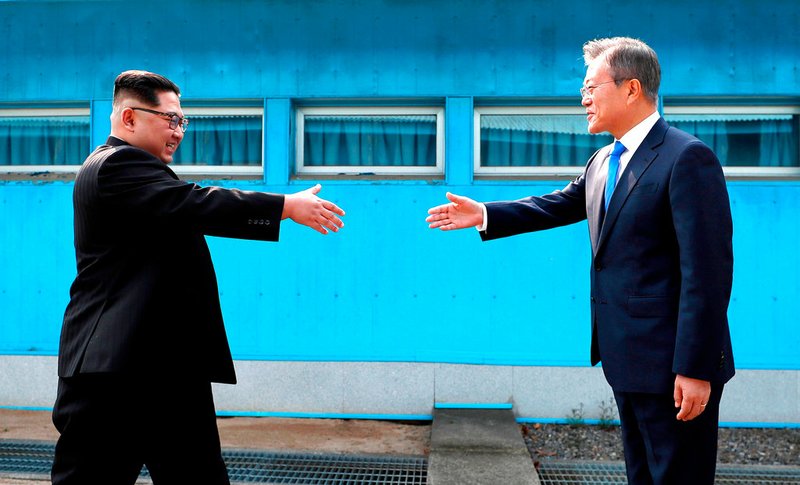 In this April 27, 2018, file photo, North Korean leader Kim Jong Un, left, prepares to shake hands with South Korean President Moon Jae-in over the military demarcation line at the border village of Panmunjom in Demilitarized Zone. South Korea says Sunday, Dec. 30, 2018, North Korean leader Kim Jong Un has sent a letter to South Korean President Moon Jae-in calling for more talks between the leaders in the new year. 