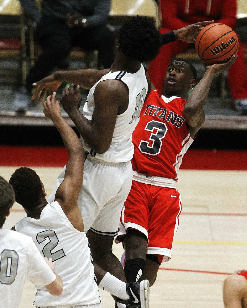 Jacksonville’s Devonte Davis (3) puts up a shot over D’Sean Perry (10) of Gulliver Prep (Fla.) during the second quarter of the Titans’ 72-68 victory in the semifinals of the King Cotton Classic. The tournament, which featured eight schools from seven states, was revived for the first time since 1999.