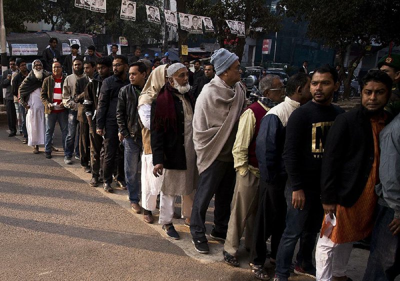 Bangladeshi men line up to cast their vote Sunday at a polling station in Dhaka, Bangladesh.