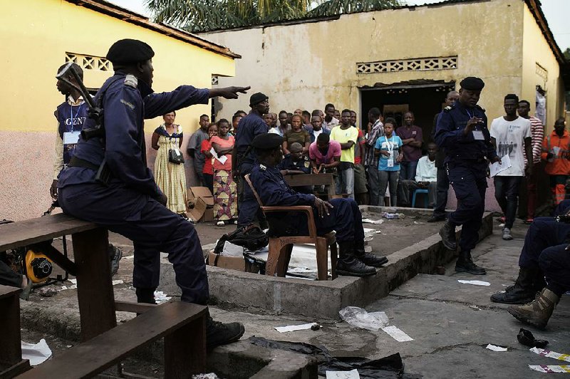 Police officers secure the Les Anges primary school Sunday in Kinshasa, Congo, as the nation votes for a new president.