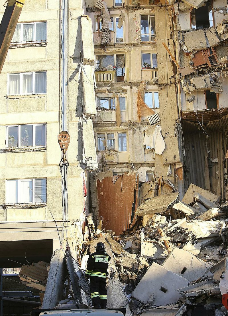 A rescue worker searches at the scene of a collapsed apartment building in Magnitogorsk, a city of 400,000 people, in Russia’s Ural Mountains, on Monday.