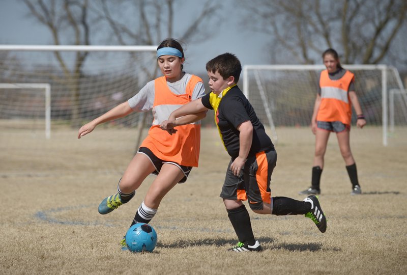 NWA Democrat-Gazette/BEN GOFF @NWABENGOFF
Nicole Orejuela, 13, tries to take a shot on goal as brother James Orejuela, 11, of Bentonville defends Monday, March 20, 2017, at the Camp Bentonville spring break soccer camp at Memorial Park in Bentonville. Bentonville Parks and Recreation partnered with soccer coaches from Sporting Arkansas to put on the camp, which runs through Wednesday. Bentonville is also hosting softball, basketball and lego camps this week. 