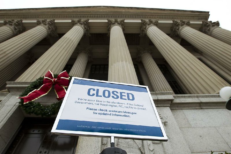 A closed sign stands Tuesday outside the entrance to the National Archives in Washington during the second week of the partial government shutdown. 