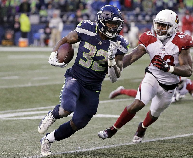 Chris Carson of the Seattle Seahawks runs the ball as Haason Reddick of the Arizona Cardinals pursues during the second half Sunday in Seattle. Carson has been a key member of the Seahawks’ successful running game this season. 