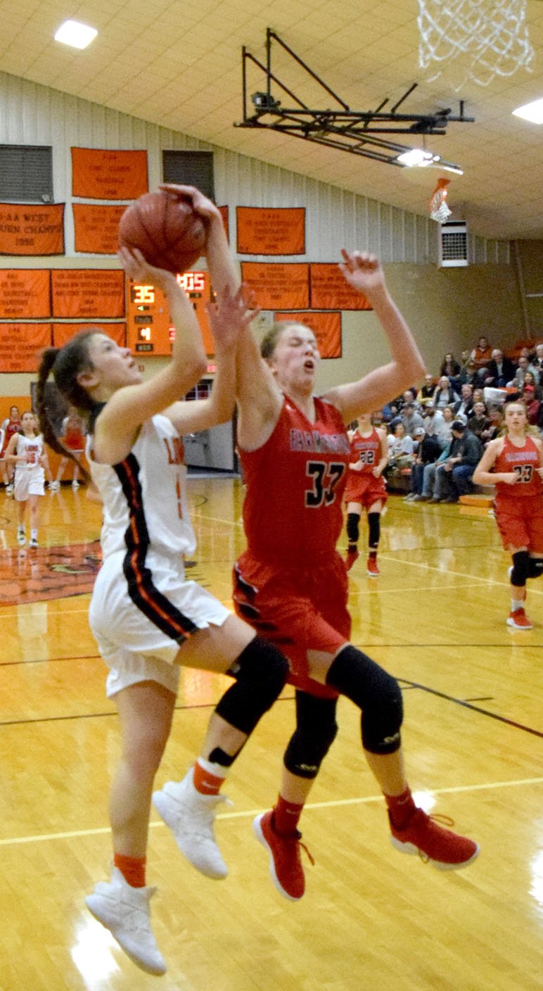 Westside Eagle Observer/MIKE ECKELS Joelle Tidwell (Farmington 33) gets a hand on the ball as Gabbi Scott (left) takes her shot during the fourth quarter of the Gravette-Farmington conference basketball contest Dec. 21 at the competition gym in Gravette.