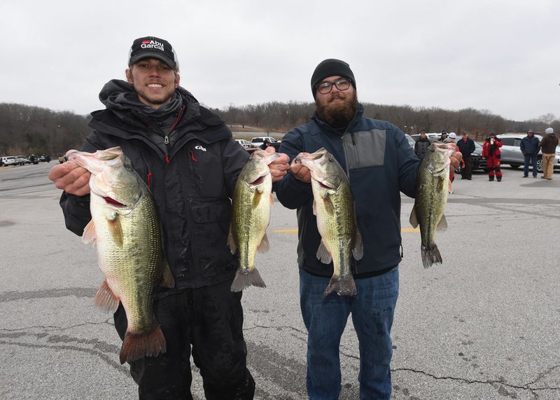 NWA Democrat-Gazette/FLIP PUTTHOFF Drew Sagely (left) And Will Lancett, both of Rogers, show some of the fish they caught Tuesday Jan. 1 2018 to win the Polar Bear bass tournament at Beaver Lake.