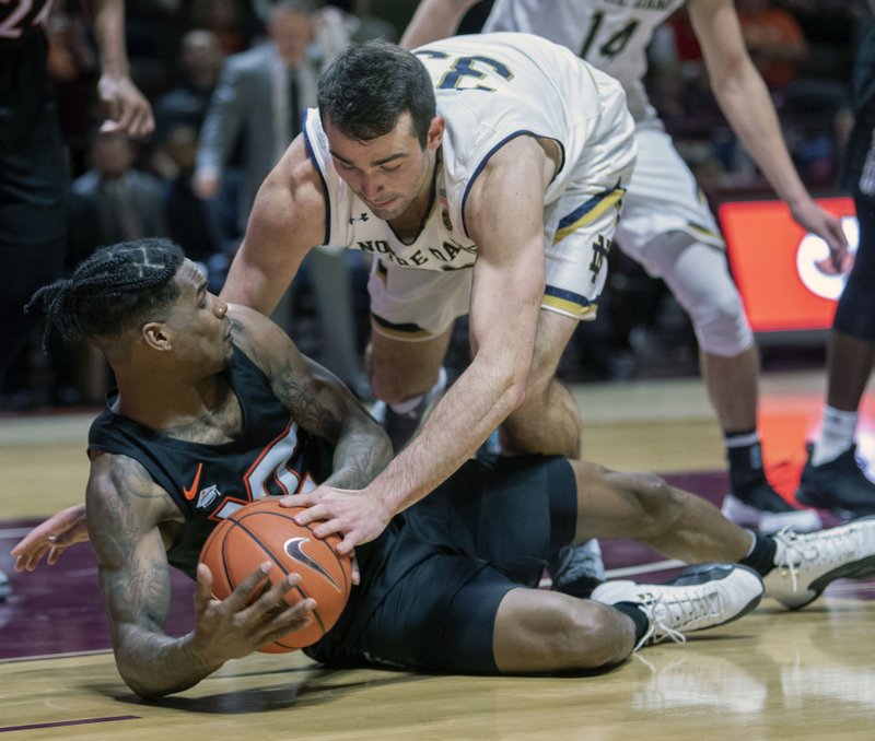 Virginia Tech guard Ahmed Hill (13) and Notre Dame forward John Mooney (33) battle for a loose ball during the first half of an NCAA college basketball game Tuesday, Jan. 1, 2019, in Blacksburg, Va. (AP Photo/Don Petersen)