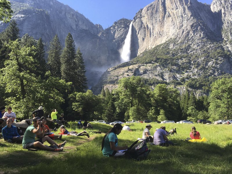  In this May 25, 2017 file photo, a class of eighth-grade students and their chaperones sit in a meadow at Yosemite National Park, Calif., below Yosemite Falls. Some of the West's iconic national parks are beginning to partially close as they deal with overflowing restrooms and vandals on the 10th day of a federal government shutdown. (AP Photo/Scott Smith, File)