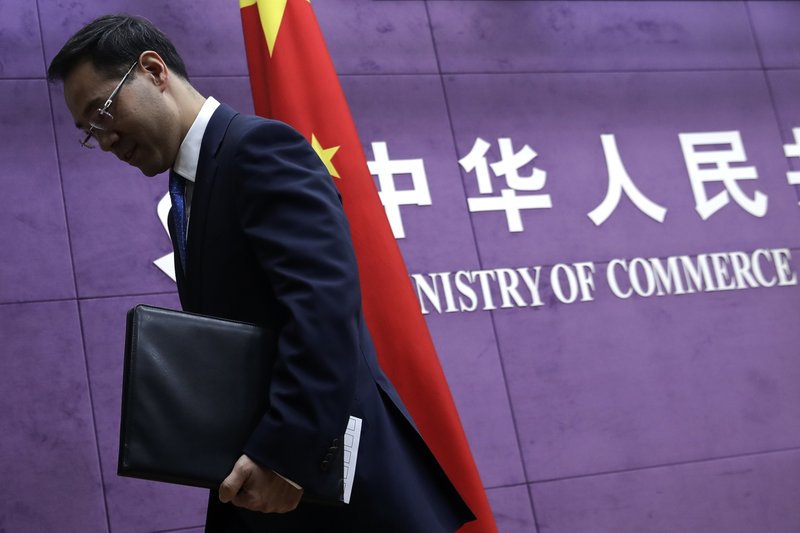 FILE- In this April 6, 2018, file photo Chinese Ministry of Commerce spokesman Gao Feng leaves after a press conference at the Ministry of Commerce in Beijing. (AP Photo/Andy Wong, File)