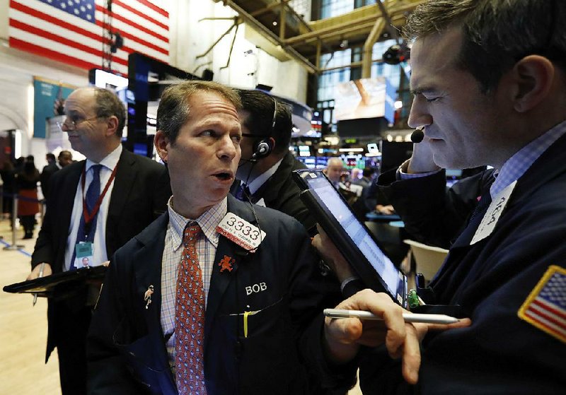 Robert Charmak (center) works with fellow traders on the floor of the New York Stock Exchange on Wednesday. 