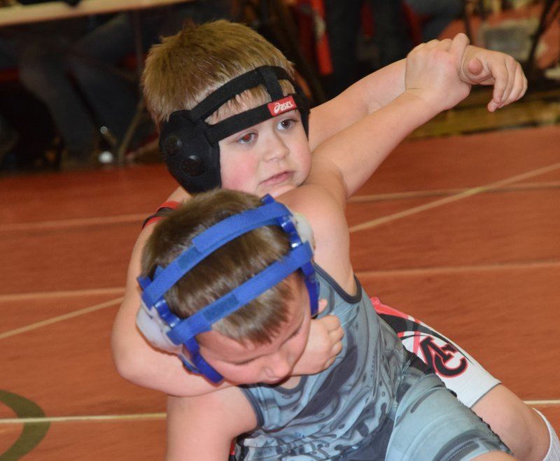 RICK PECK/SPECIAL TO MCDONALD COUNTY PRESS Chandler Moffett of the McDonald County Youth Wrestling Club takes Noah Midcap of Webb City down on his way to a 9-4 win in the six and under, 55-pound division at the McDonald County Youth Wrestling Tournament held Dec. 29 at MCHS.