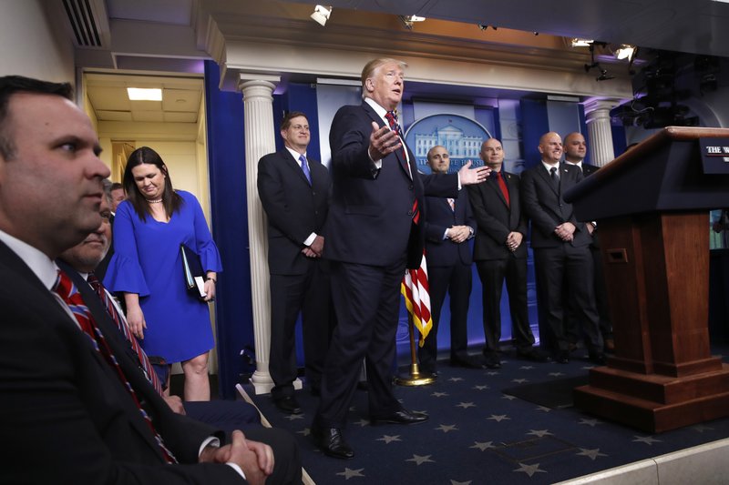 President Donald Trump gestures as he arrives in the press briefing room, Thursday Jan. 3, 2019, to speak about border security at the White House in Washington. At left is press secretary Sarah Huckabee Sanders. (AP Photo/Jacquelyn Martin)

