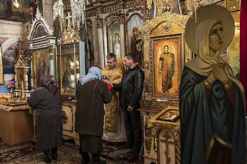 The Rev. Oleksandr Kolesov, a Russian Orthodox priest in Ukraine who was interrogated by the Ukrainian security agency, spends time with parishioners St. Michael’s Church in Chernytsya, Ukraine. 