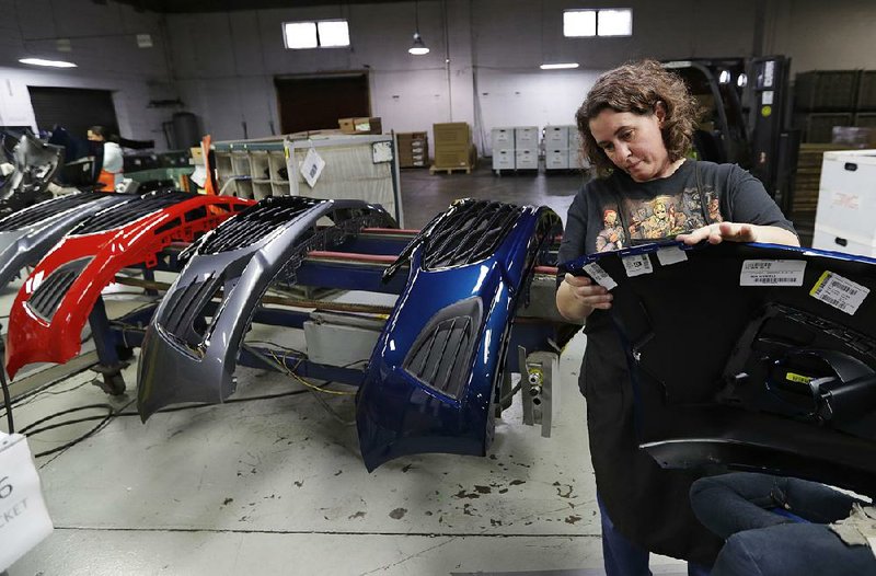 An assembly worker inspects the front end of a General Motors Chevrolet Cruze in November at Jamestown Industries in Youngstown, Ohio. The factory production index, compiled from a survey of manufacturers, has fallen sharply from a 14-year high in August. 
