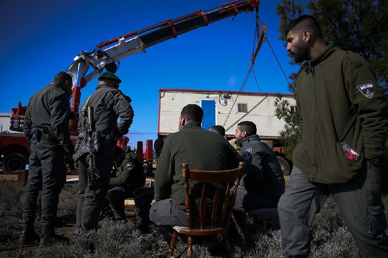 Israeli forces work Thursday to remove people from the West Bank settlement outpost of Amona. 