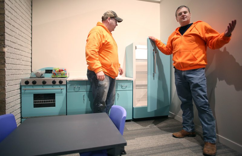 File Photo/DAVID GOTTSCHALK John Burroughs (right), director of the Rogers Historical Museum, talks with Robert Rousey (left), curator of education, in the child-size kitchen inside the renovated Hailey Building at the Rogers Historical Museum in downtown Rogers.