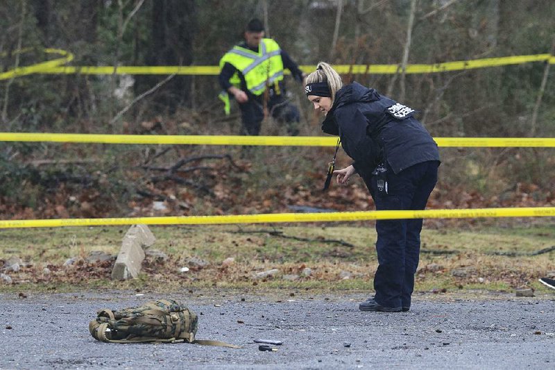 Little Rock police and crime-scene technicians investigate Friday at West Roosevelt Road and Martin Luther King Jr. Drive, where two people were fatally shot.