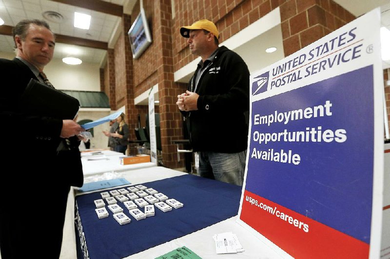 A recruiter from the U.S. Postal Service (right) speaks with an attendee of a job fair at a high school in Cheswick, Pa. The Labor  Department reported Friday that December job gains were robust and the average hourly wage rose 3.2 percent from a year ago. 