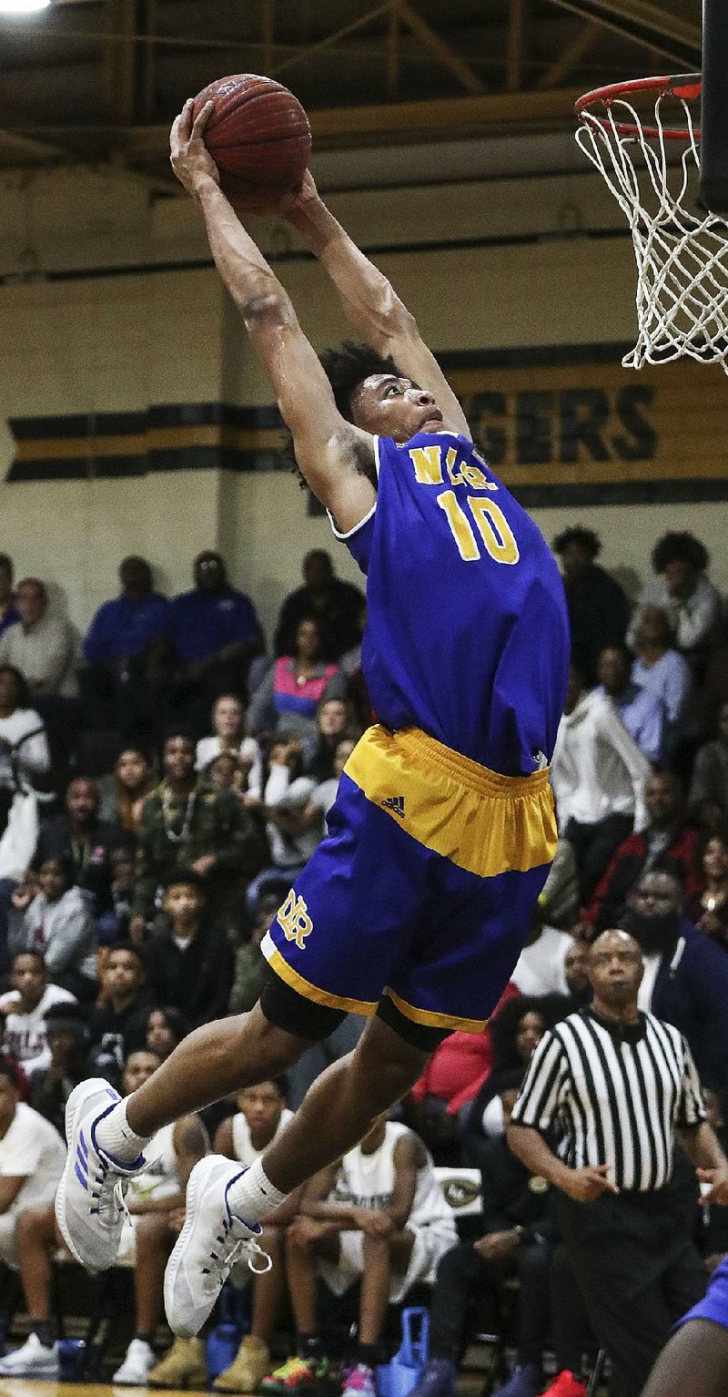 North Little Rock’s Collin Moore goes up for a dunk during the Charging Wildcats’ 67-63 overtime victory
over Little Rock Central at Tiger Fieldhouse. For more photos, visit arkansasonline.com/galleries.