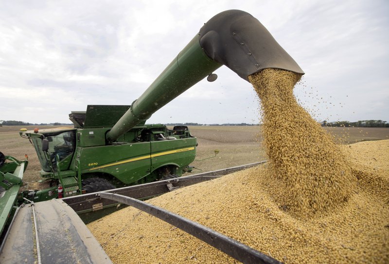 FILE - In this Friday, Sept. 21, 2018, file photo, soybeans are offloaded from a combine during the harvest in Brownsburg, Ind. China&#x2019;s government says American envoys will visit Beijing on Monday for talks over a tariff fight that threatens to hobble global economic growth. (AP Photo/Michael Conroy, File)