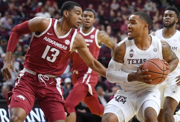 Texas A&M's TJ Starks (2) faces Arkansas' Mason Jones (13) near the basket in the first half of an NCAA college basketball game Saturday, Jan. 5, 2019, in College Station, Texas. (Laura McKenzie/College Station Eagle via AP)