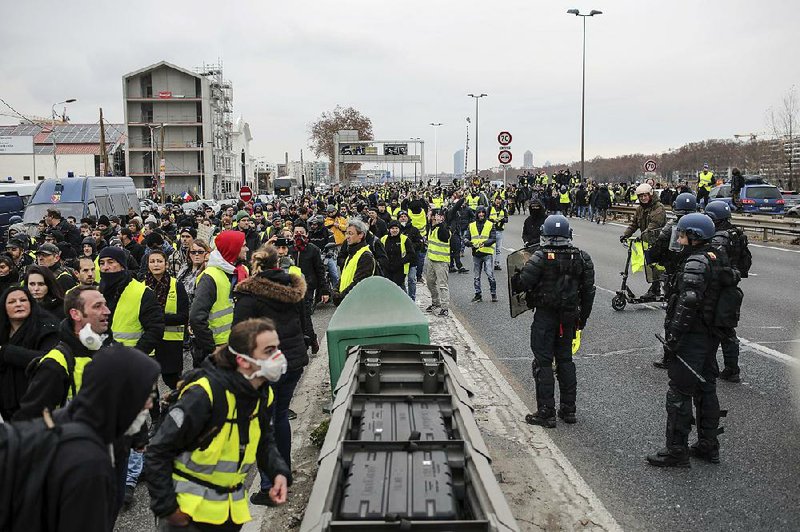 Protesters march peacefully while blocking traffic Saturday in Lyon, France, one of several cities where demonstrations were held. Things were not so peaceful in Paris, and authorities said confrontations broke out in Bordeaux and Rouen. 