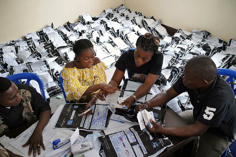 Congolese officials count presidential-election votes Friday in Kinshasa. Ballots at the compilation center were gathered from more than 900 polling stations. 