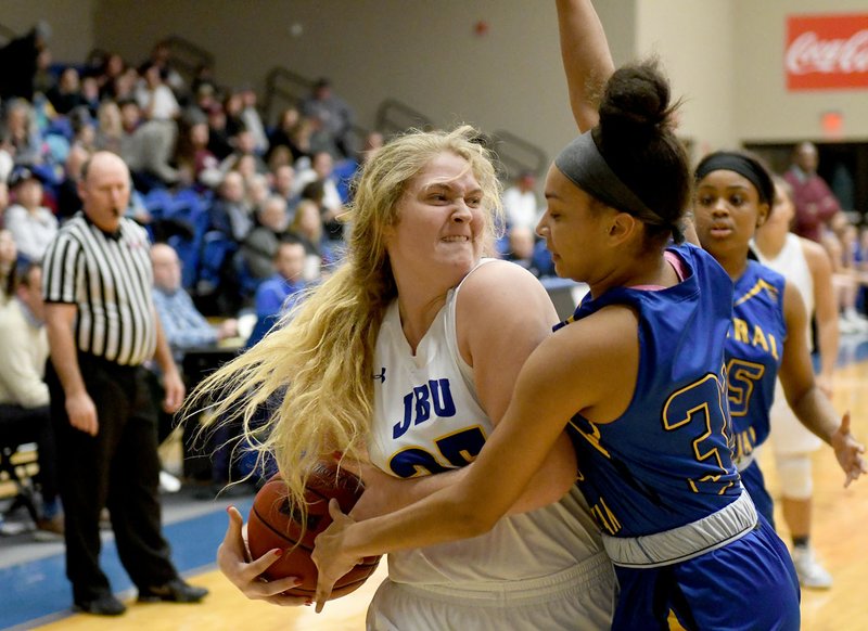Bud Sullins/Special to Siloam Sunday John Brown freshman Kayla Nelson grabs a rebound as Central Christian (Kan.) forward Holly Golden defends on the play during Thursday's game at Bill George Arena. JBU defeated Central Christian 83-60.